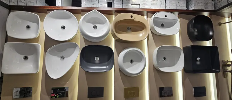 Wall of twelve table-top and wall-hung basins with flush plates at Mahalaxmi Ceramics showroom, Kothrud