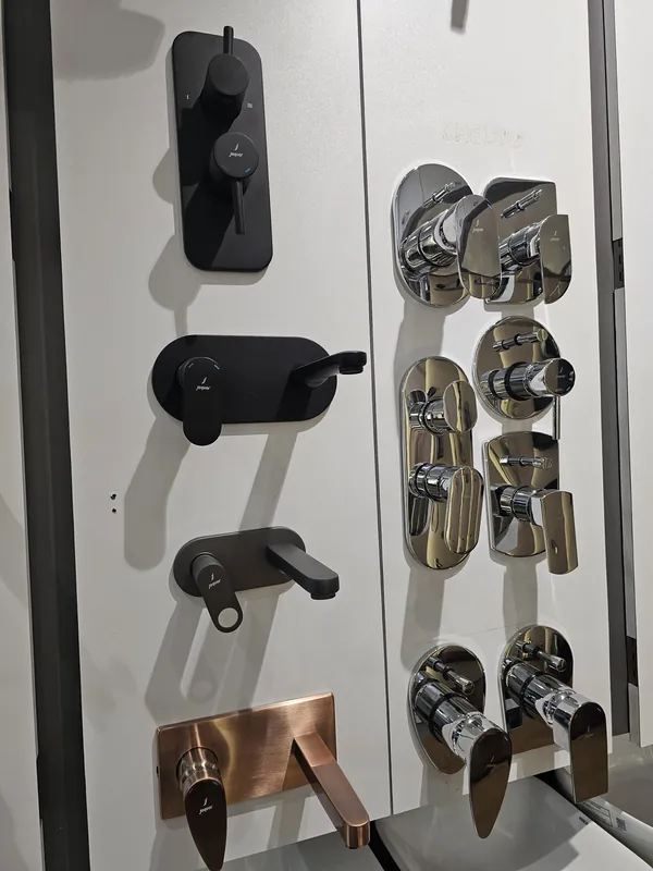 Panel of Jaquar concealed diverters and wall mixers in chrome, black matt and antique copper at Mahalaxmi Ceramics