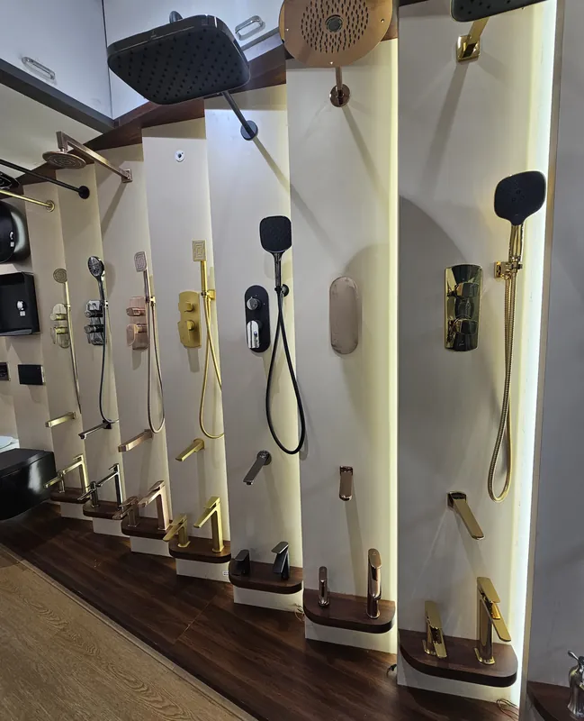 Jaquar shower display wall at Mahalaxmi Ceramics with overhead showers, hand showers, diverters and basin mixers in several finishes
